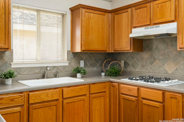 kitchen featuring decorative backsplash, sink, and white gas cooktop