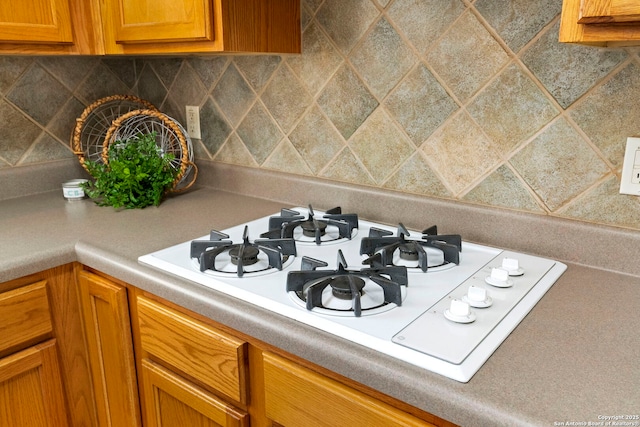 kitchen with tasteful backsplash and white gas stovetop