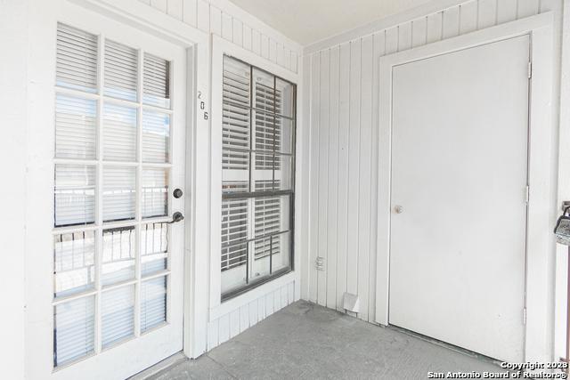 doorway to outside with wood walls