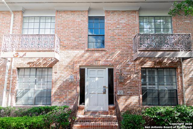 view of exterior entry with a balcony