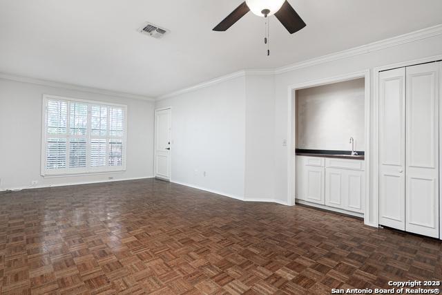 unfurnished living room with dark parquet floors and ornamental molding