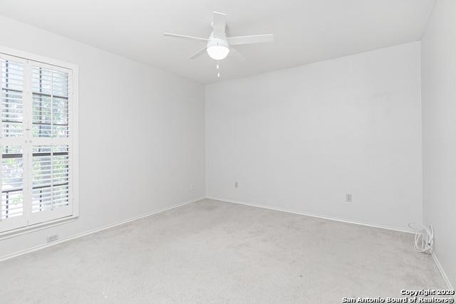 carpeted empty room featuring ceiling fan