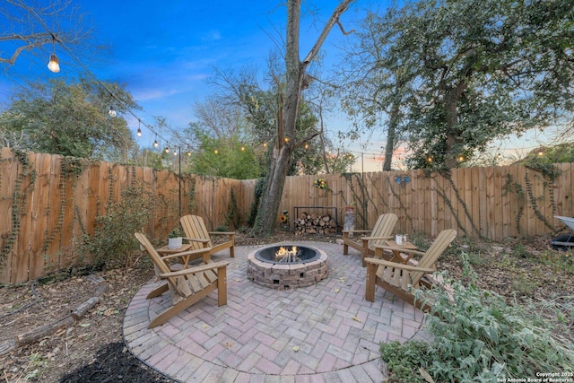 patio terrace at dusk featuring a fire pit