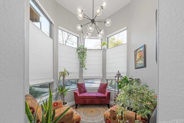 sunroom featuring a healthy amount of sunlight and a chandelier