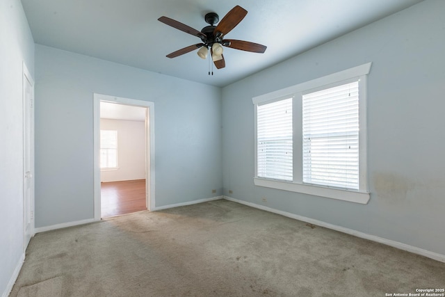 spare room featuring light carpet and ceiling fan