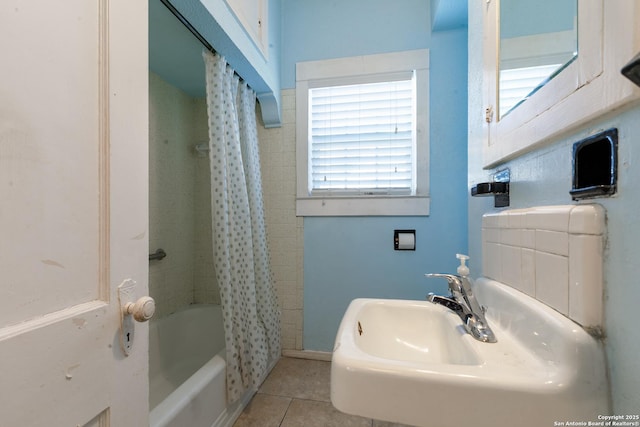 bathroom featuring sink, shower / bath combo with shower curtain, and tile patterned flooring