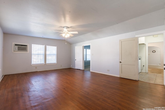 unfurnished room featuring ceiling fan, wood-type flooring, lofted ceiling, and a wall unit AC