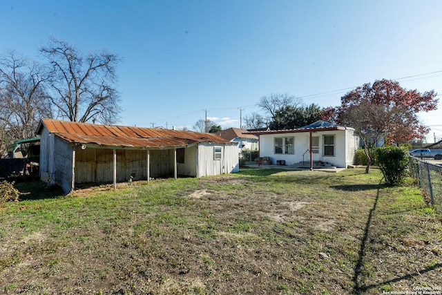 rear view of house with an outbuilding and a yard