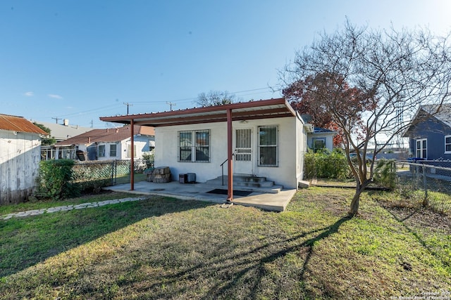 rear view of house featuring a patio area and a lawn