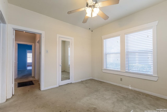 spare room featuring ceiling fan and light colored carpet