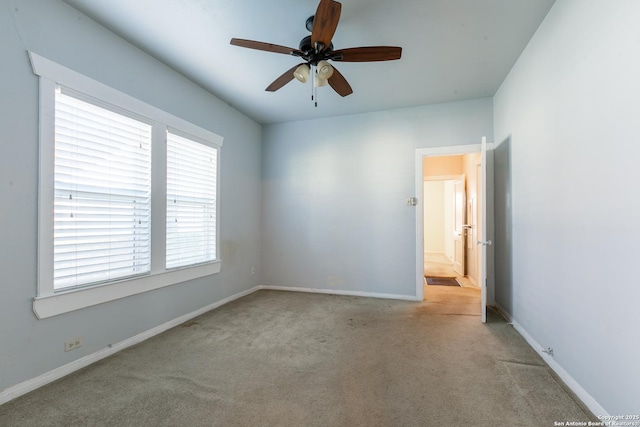 carpeted spare room with ceiling fan