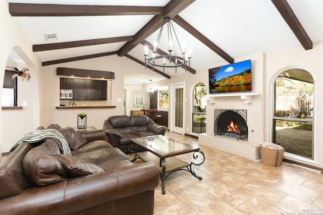 living room with vaulted ceiling with beams and a chandelier