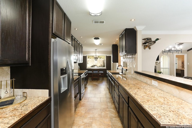 kitchen with sink, crown molding, dark brown cabinets, pendant lighting, and stainless steel appliances