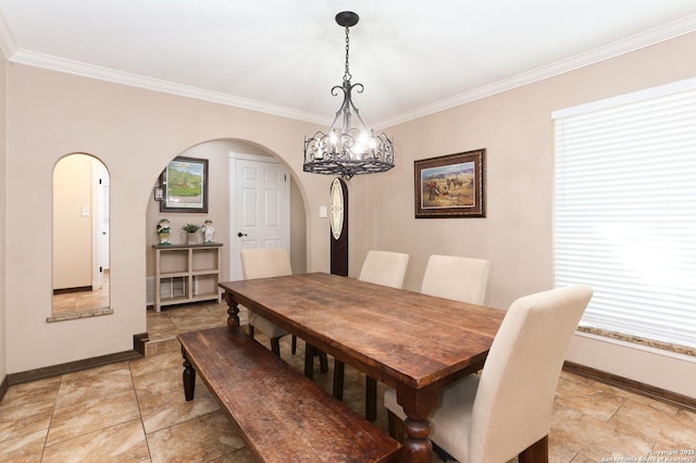 dining space with ornamental molding and a chandelier