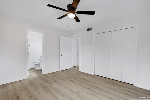 unfurnished bedroom featuring ceiling fan, light hardwood / wood-style floors, a closet, and ensuite bathroom