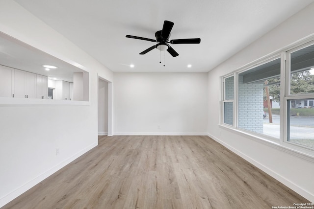 empty room with ceiling fan and light hardwood / wood-style flooring