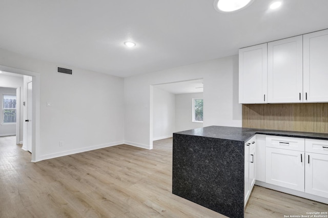 kitchen with white cabinetry, kitchen peninsula, and light wood-type flooring