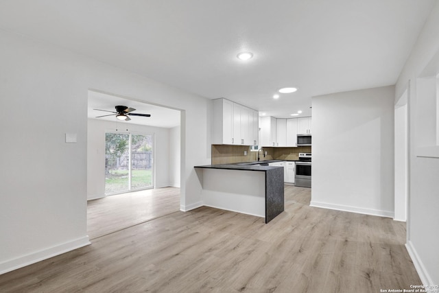 kitchen featuring kitchen peninsula, appliances with stainless steel finishes, white cabinets, tasteful backsplash, and light hardwood / wood-style floors