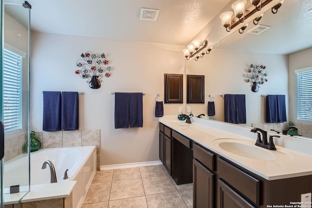 bathroom with tile patterned flooring, vanity, and a tub