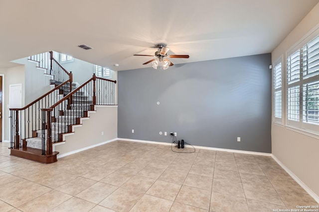 tiled spare room with ceiling fan