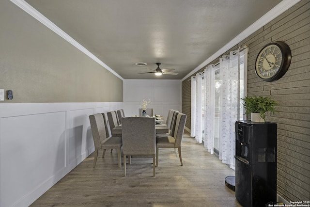 dining space with hardwood / wood-style flooring, crown molding, and ceiling fan