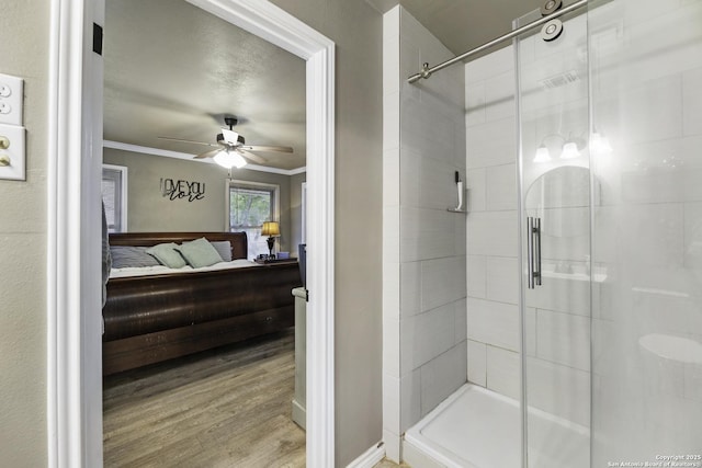 bathroom with ceiling fan, crown molding, a shower with door, and wood-type flooring