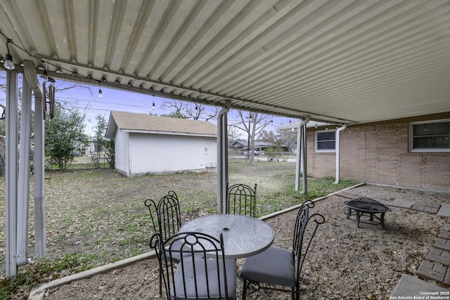 view of patio featuring an outdoor fire pit and a storage shed