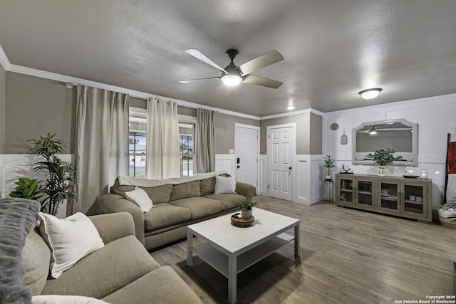 living room featuring ceiling fan, crown molding, and wood-type flooring