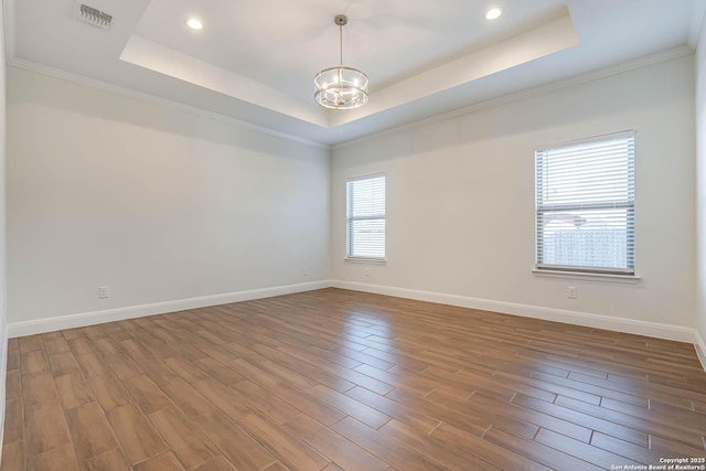 unfurnished room with a notable chandelier, crown molding, and a tray ceiling