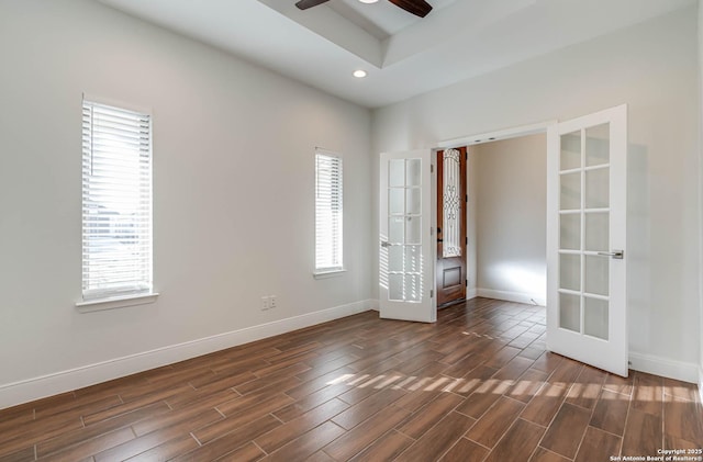 empty room with a healthy amount of sunlight, ceiling fan, and french doors