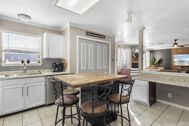 kitchen featuring sink, white cabinetry, and light tile patterned floors