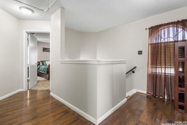 hall with dark hardwood / wood-style floors and a textured ceiling