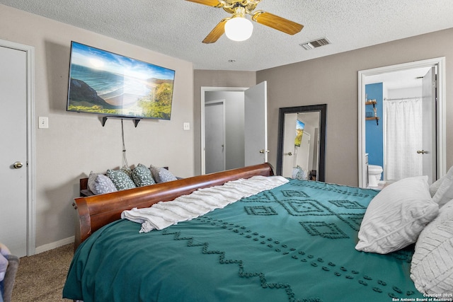 bedroom featuring ceiling fan, a textured ceiling, ensuite bathroom, and carpet floors