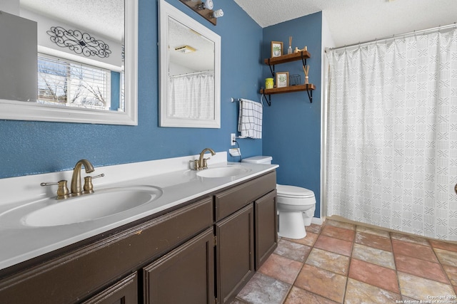 bathroom with toilet, a textured ceiling, and vanity