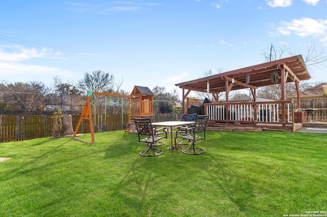 view of yard featuring a deck and a playground