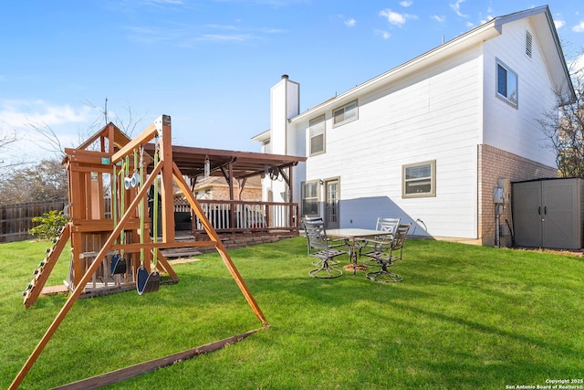 exterior space with a playground, a yard, and a storage unit