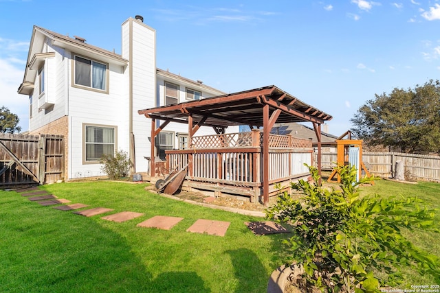 rear view of property with a playground, a deck, and a yard