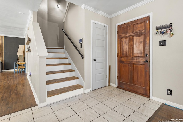 tiled foyer entrance featuring crown molding