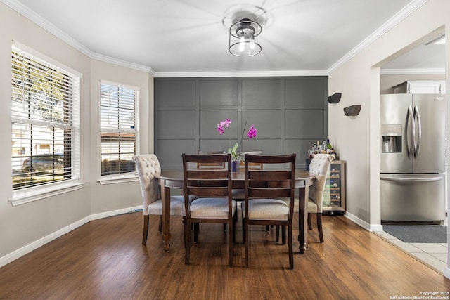 dining space featuring ornamental molding, wine cooler, and hardwood / wood-style floors