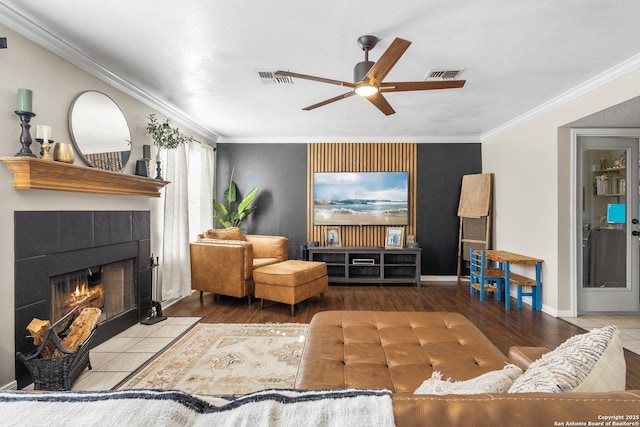 living room with a fireplace, hardwood / wood-style floors, ceiling fan, and crown molding