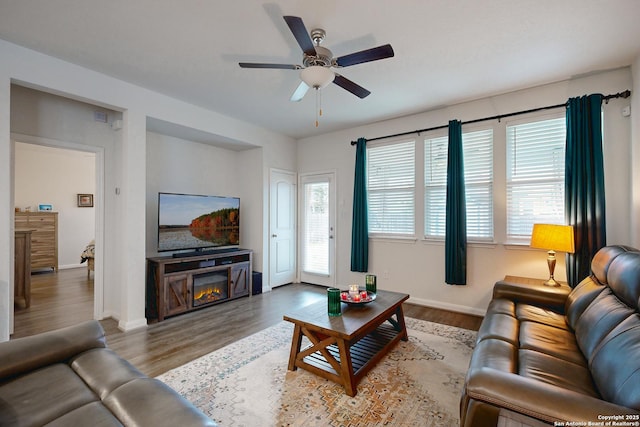 living room with ceiling fan, dark wood-type flooring, and a fireplace