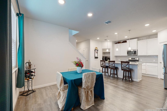 dining space featuring light wood-type flooring