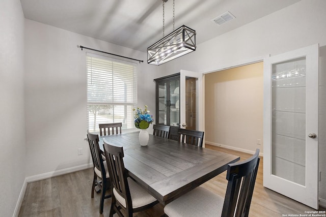 dining room with light hardwood / wood-style floors and lofted ceiling