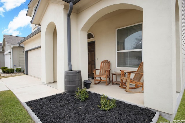 doorway to property featuring a porch and a garage