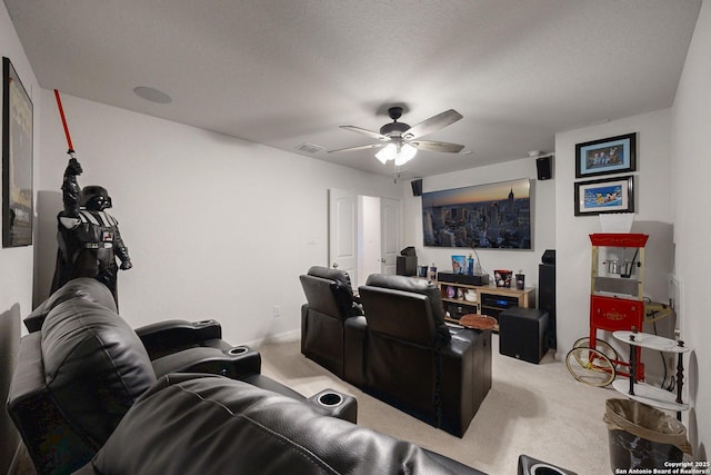 carpeted home theater room with a textured ceiling and ceiling fan