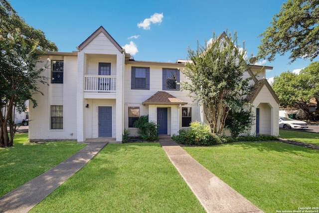 view of front of house with a balcony and a front lawn