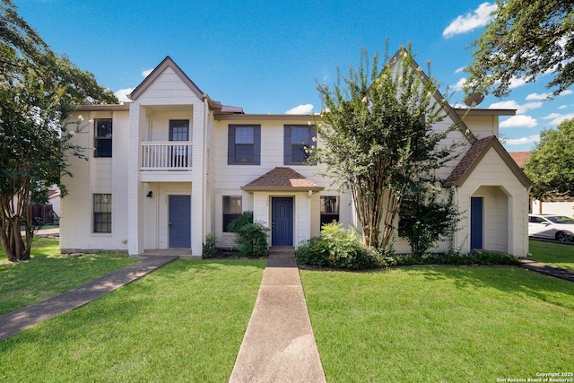 view of front of property with a balcony and a front lawn