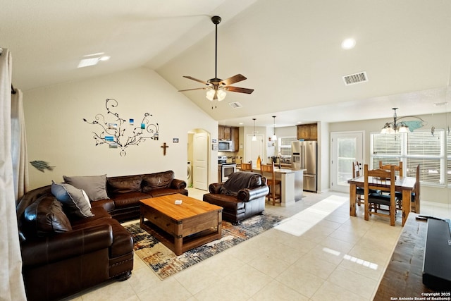 tiled living room featuring ceiling fan with notable chandelier and vaulted ceiling