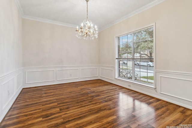 empty room featuring a notable chandelier, a healthy amount of sunlight, ornamental molding, and dark hardwood / wood-style flooring