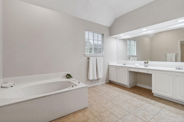 bathroom with vanity, a bathing tub, tile patterned floors, and lofted ceiling